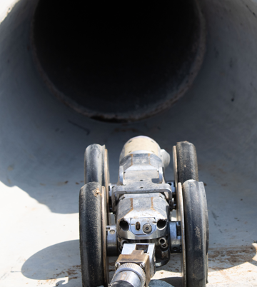 CCTV inspection camera positioned at the entrance of a pipeline, showcasing advanced technology for underground utility services.