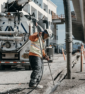 Worker operating hydro excavation equipment on construction site, demonstrating Nor-Cal Pipeline Services' advanced pipe jetting technology for effective debris removal.